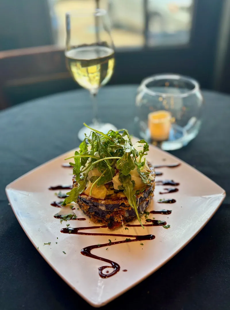 A plated Cavalli appetizer with arugula and balsamic glaze