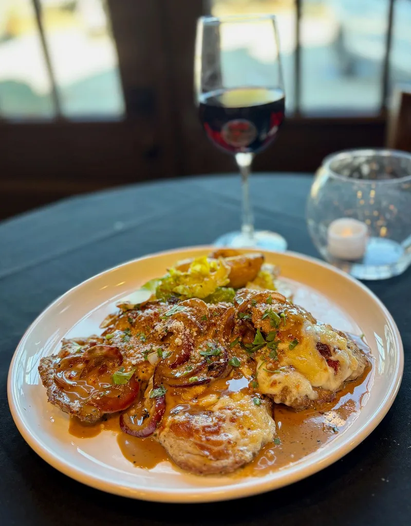One of Cavalli's plated entrées, served with a glass of red wine
